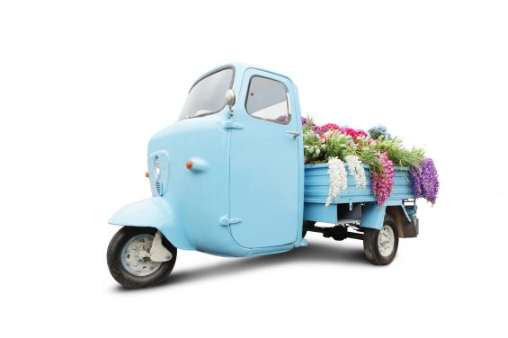 Vintage motorbike with flowers in trunk isolated on white.