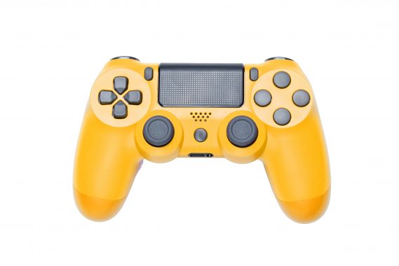 Modern yellow gamepad (joystick) on gray background. Top view